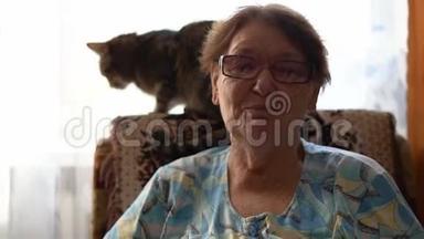 老妇人坐在扶手椅上，抱着一只猫。 在家爱朋<strong>友爱</strong>宠物